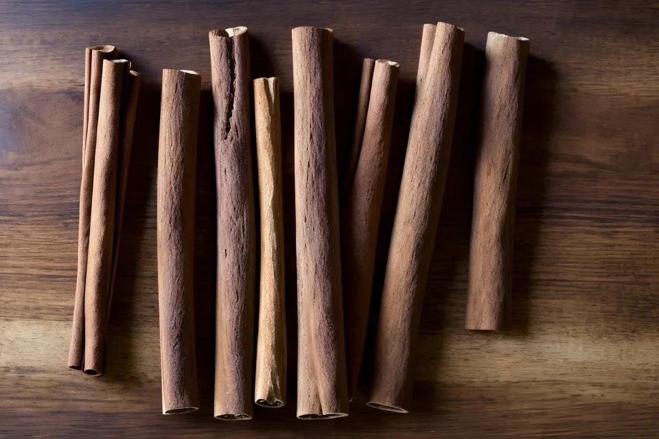 Comparison of Ceylon cinnamon and Cassia cinnamon sticks on a wooden board.